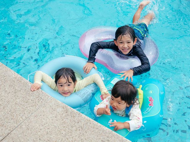 屋外プールで浮き輪遊びの画像
